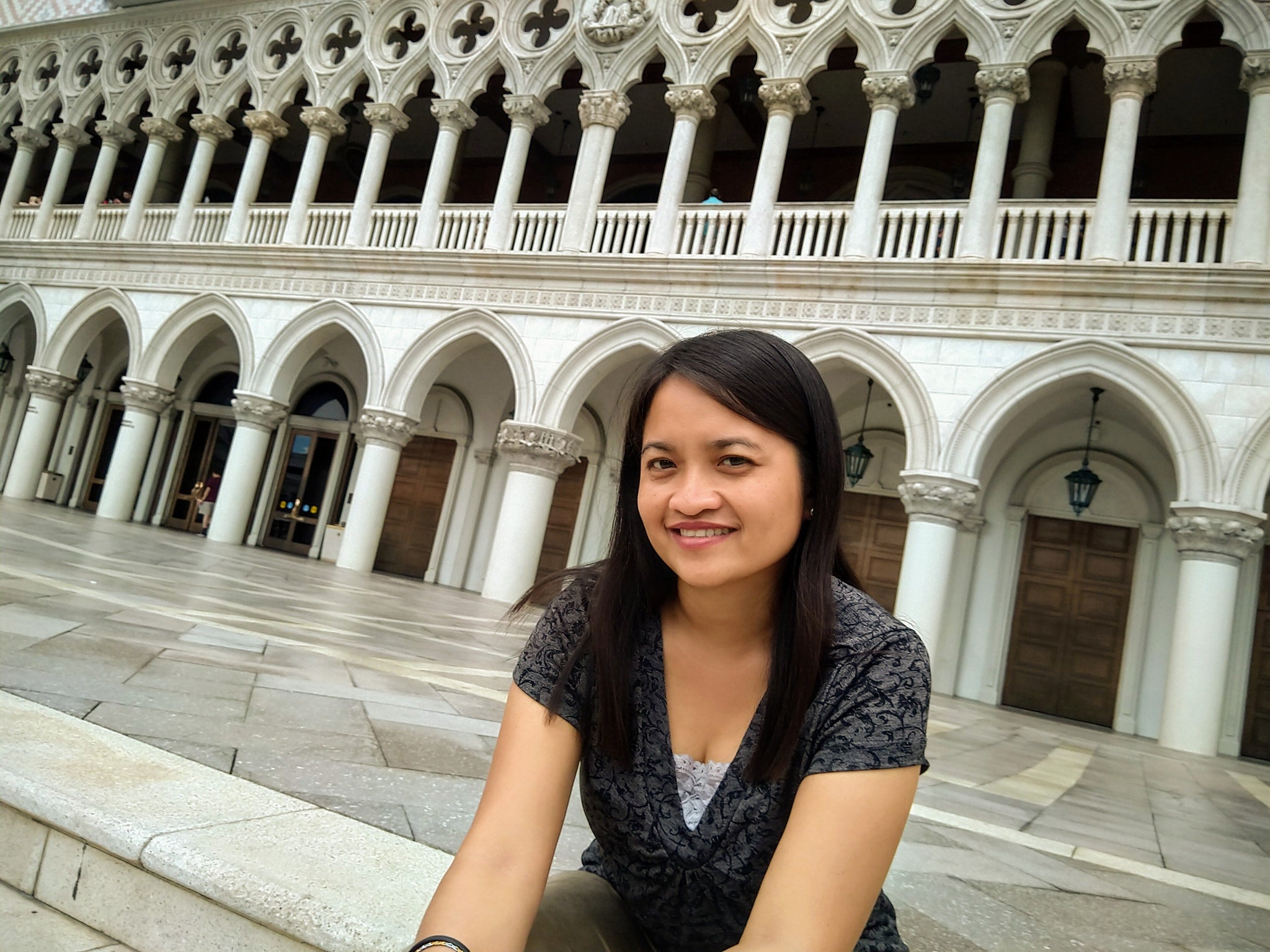 Jasmin sitting in front of an elegant building